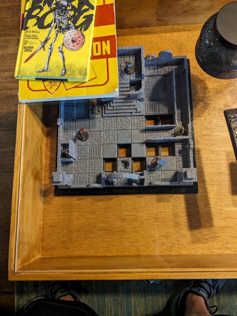 the beginnings of a 3d printed dungeon displayed inside the coffee table